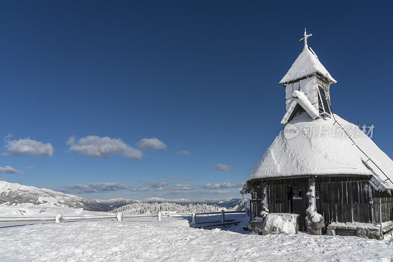 木制教堂在冬季高原牧场Velika Planina